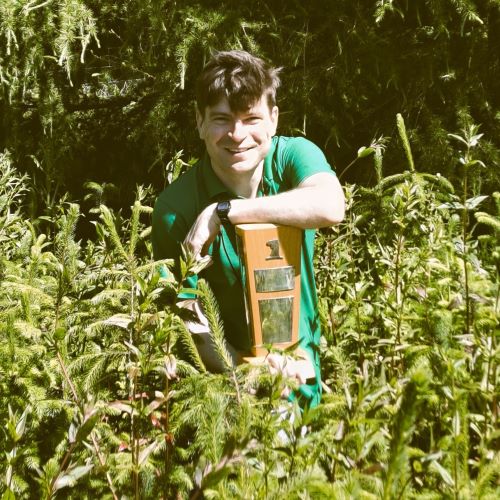 Image of Domen Finžgar wearing a green shirt in amongst some young trees