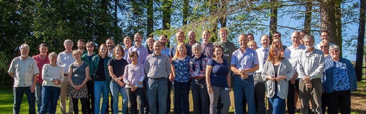 Image of a group of FR staff photographed on a sunny day in front of trees growing at our Northern Research Station.