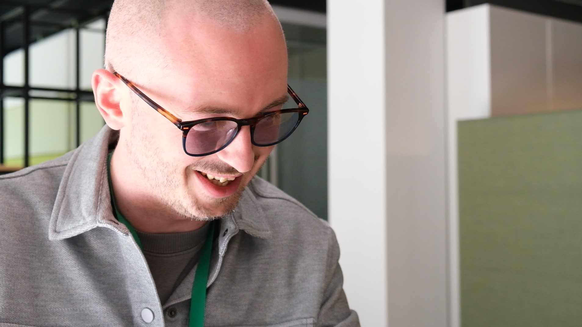 A photo of Alex at his desk smiling