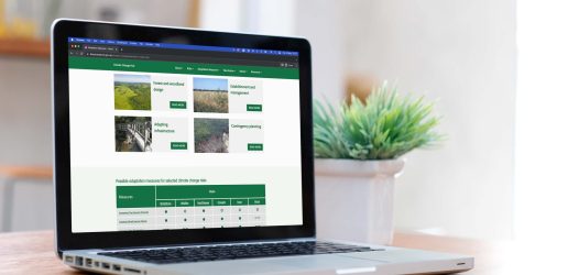 A laptop displays the Forest Research Climate Change Hub.