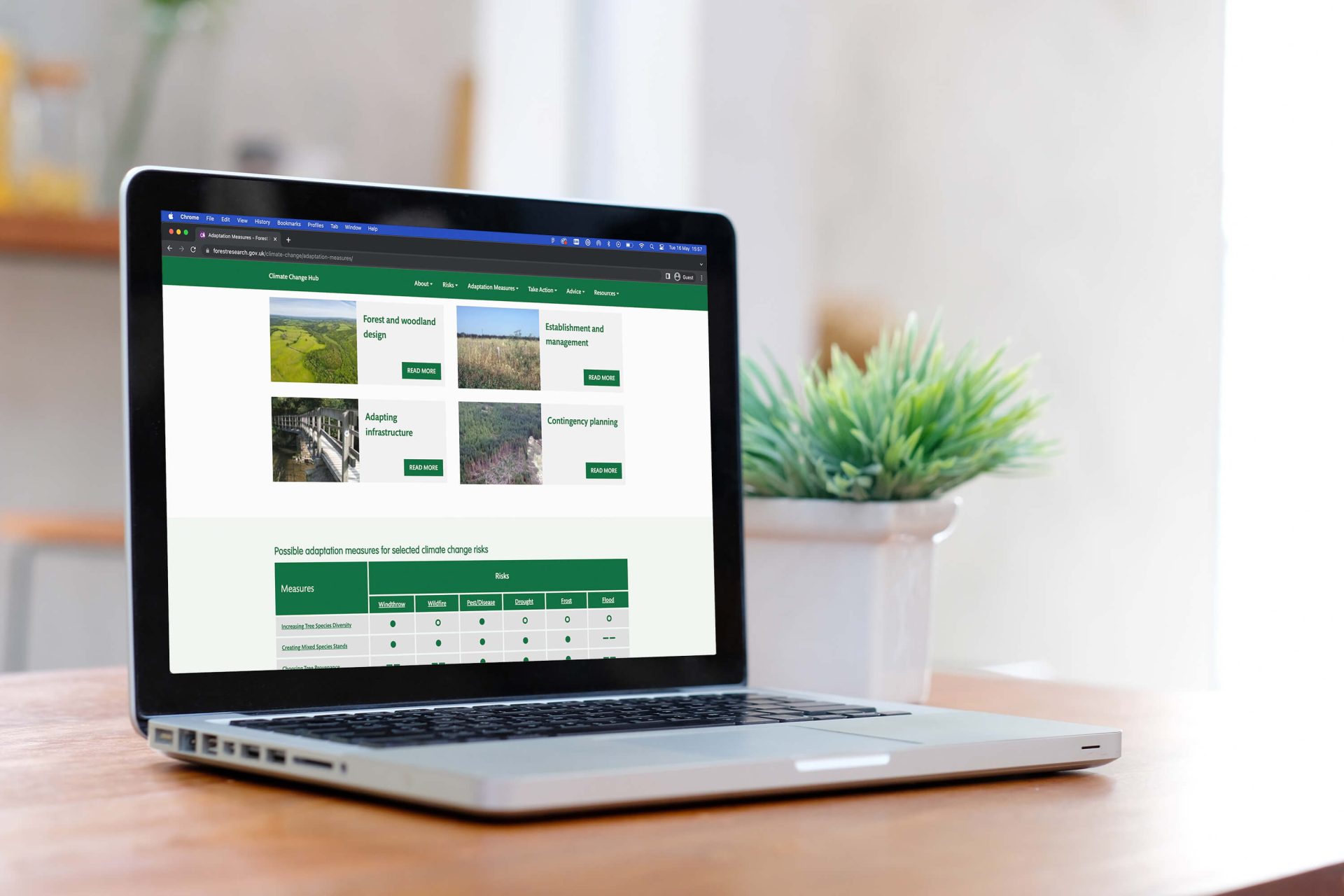 A laptop displays the Forest Research Climate Change Hub.