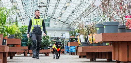 Man walking with dog on lead in garden centre