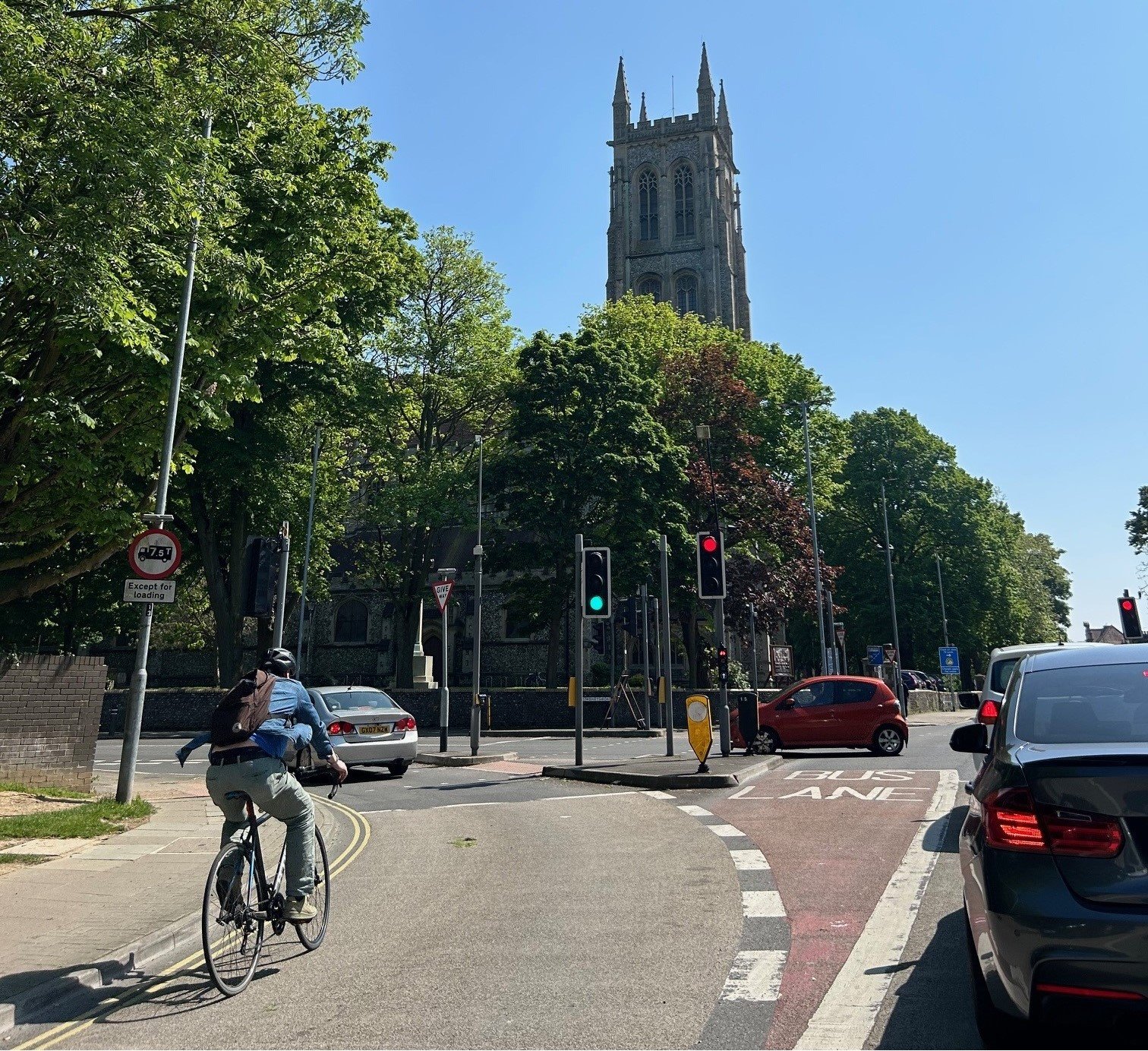 Vehicles and a cyclist on a road in Portsmouth with trees