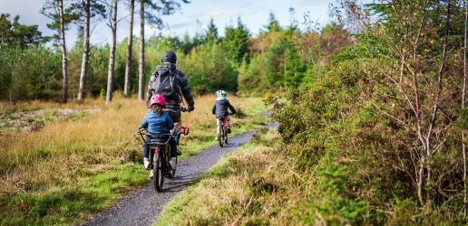 Family cycling in woods