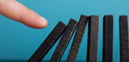 Finger setting off domino effect.
