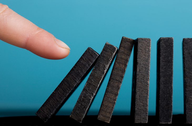Finger setting off domino effect.