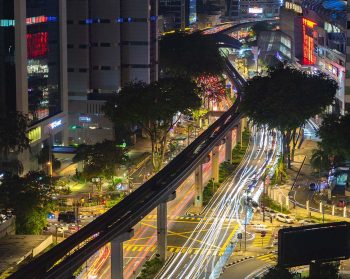 Kuala Lumpur traffic at night, depicting the monorail and a busy intersection.
