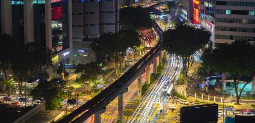 Kuala Lumpur traffic at night, depicting the monorail and a busy intersection.