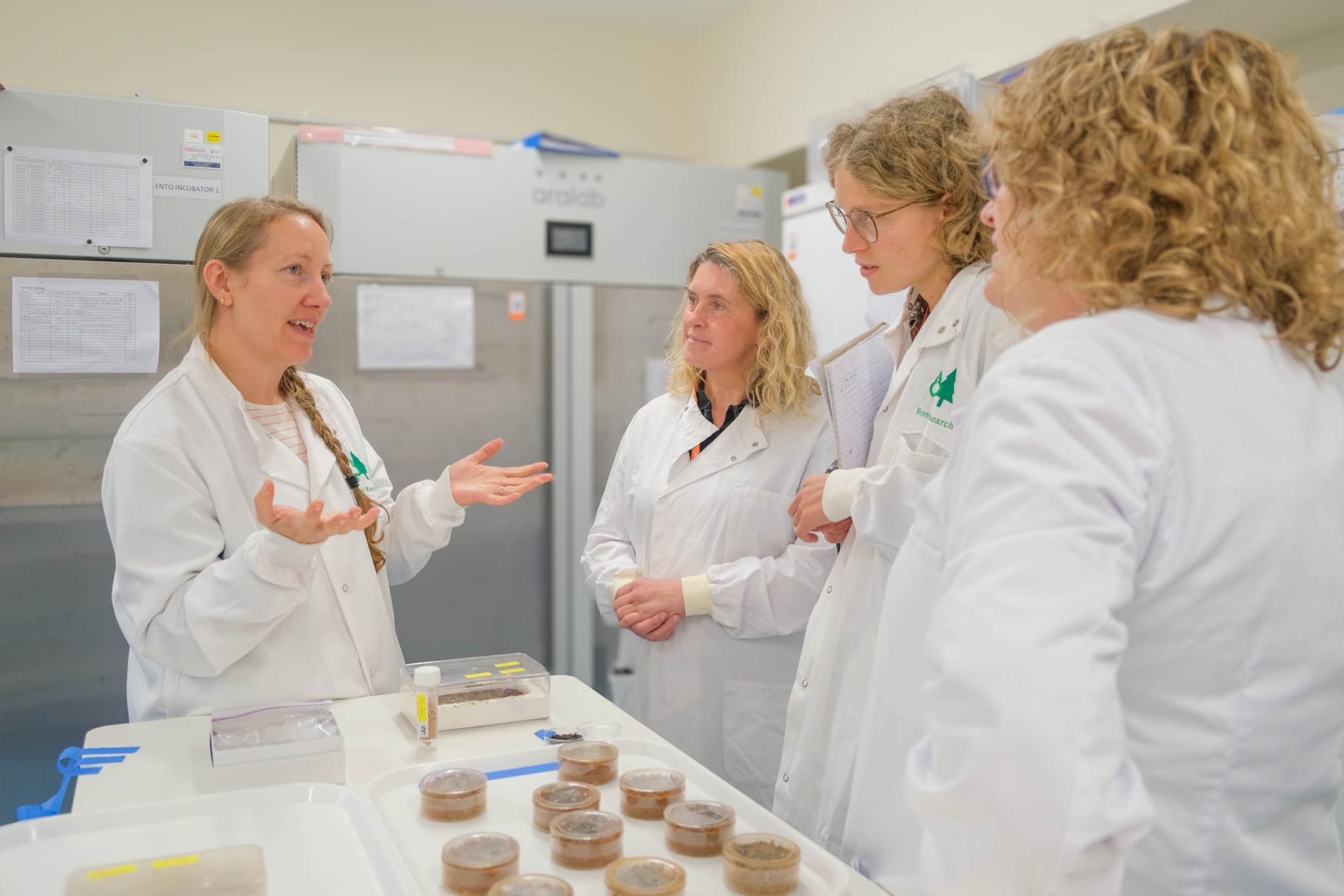 Lab technician talks as volunteers listen. 